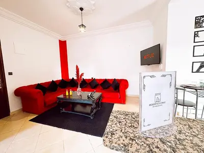 a living room with a red couch and a table at Residence Chay - Luxury Appart in Ouarzazate