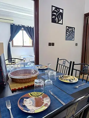 a table with plates and glasses on a blue table cloth at Residence Chay - Luxury Appart in Ouarzazate