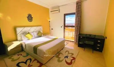 a bedroom with a bed and a window with a view at Residence Chay - Luxury Appart in Ouarzazate