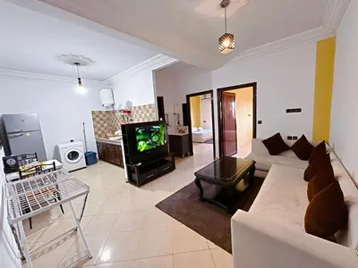 a living room with a white couch and a tv at Residence Chay - Luxury Appart in Ouarzazate