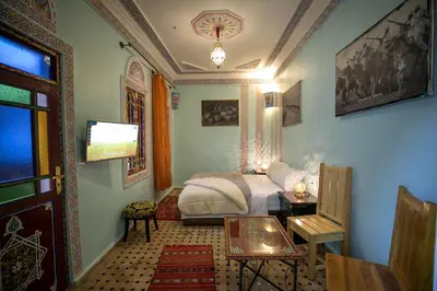 a bedroom with a bed and a table in a room at Riad Noha in Fès
