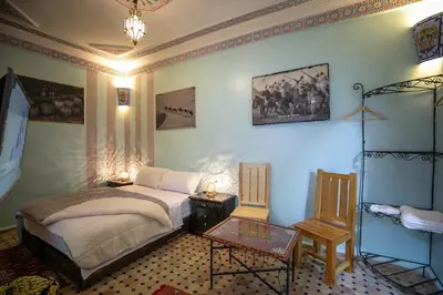 a bedroom with a bed and a table in it at Riad Noha in Fès