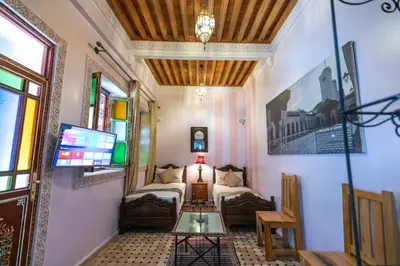 a bedroom with a bed and a table in a room at Riad Noha in Fès