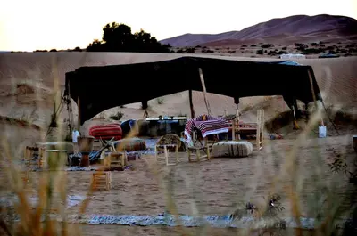 a tent with chairs and tables in the desert at Tuareg Luxury Camp in Merzouga