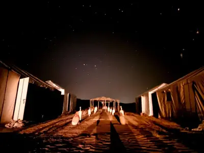 a group of white birds sitting on a bridge at night at Tuareg Luxury Camp in Merzouga