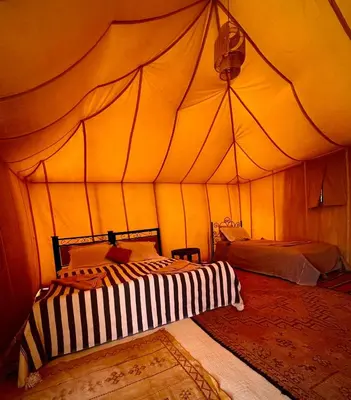 a room with two beds in a tent at Tuareg Luxury Camp in Merzouga