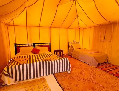 a bedroom with two beds in a tent at Tuareg Luxury Camp in Merzouga