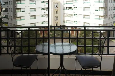 a table and two chairs on a balcony with a window at Hotel Nouzha in Fès