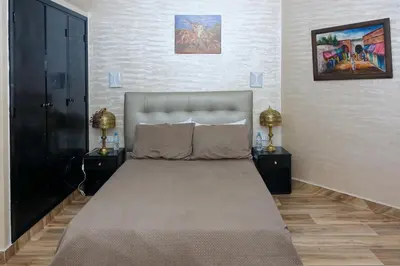 a bedroom with a large bed with two night stands at Hotel Nouzha in Fès