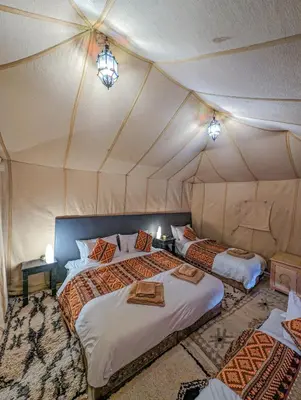 a bedroom with two beds in a tent at Camel Luxury Camp in Merzouga