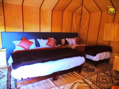 a bedroom with two beds in a tent at Camel Luxury Camp in Merzouga