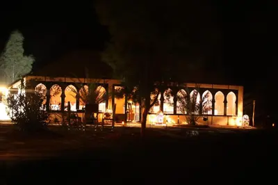 a building lit up at night with lights at Camel Luxury Camp in Merzouga