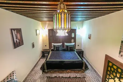 a room with a bed and a chandelier at Riad Hadia Fes - Prestige Stay in Fès