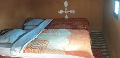 a bed in a room with a bedspread on it at Camp Mhamid Sahara Tours in Mhamid