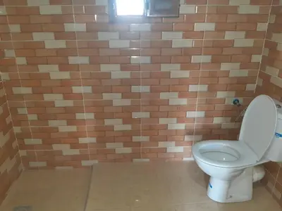a bathroom with a toilet and a brick wall at Camp Mhamid Sahara Tours in Mhamid