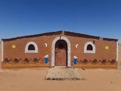a mural on the side of a building with a door at Camp Mhamid Sahara Tours in Mhamid