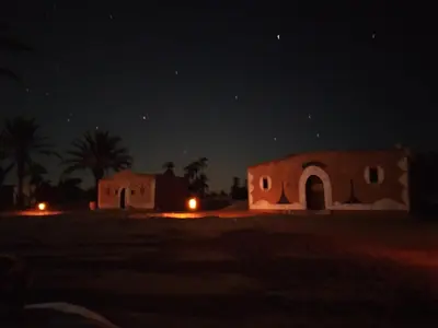 a night view of two houses in the desert at Camp Mhamid Sahara Tours in Mhamid