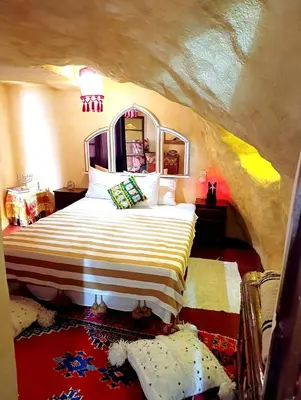 a bedroom with a large bed in a cave at Grotte Thami in Bhalil