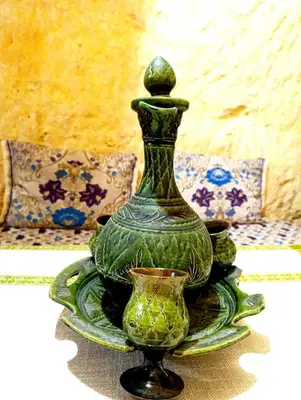 a green vase on a plate on a table at Grotte Thami in Bhalil