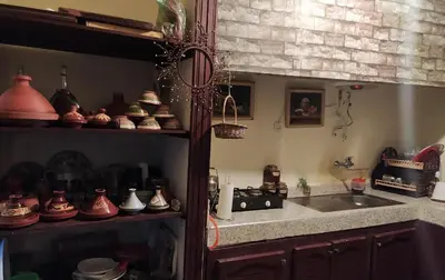 a kitchen with a sink and a counter with pots and pans at Grotte Thami in Bhalil