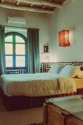 a bedroom with two beds and a window at taman'art space in Aït Ben Haddou