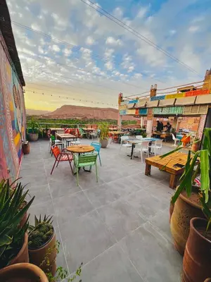 a patio with tables and chairs and tables and plants at taman'art space in Aït Ben Haddou