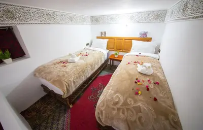 a bedroom with two beds and flowers on the floor at Riad Basma Fes - Brand New Bathrooms & AC in Fès