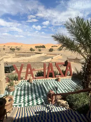 a sign that says vaan in the middle of a desert at Kasbah Azalay Merzouga takojt in Merzouga