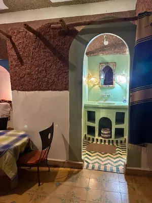 a room with a bathroom with a sink and a table at Kasbah Azalay Merzouga takojt in Merzouga