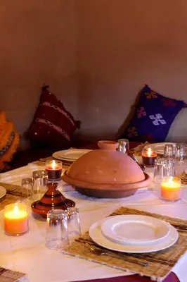 a table with some candles and plates and candles at Riad Nomad in Foum Mharech