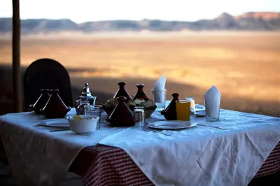 a table with bottles and plates on top at Riad Nomad in Foum Mharech