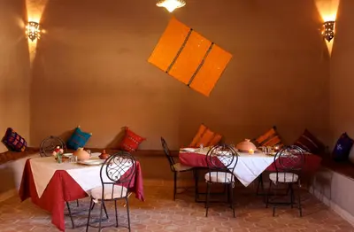 a dining room with two tables with red and white table cloth at Riad Nomad in Foum Mharech