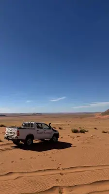 a white truck parked in the middle of the desert at Riad Nomad in Foum Mharech