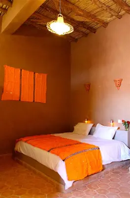 a bedroom with two beds with orange blankets on them at Riad Nomad in Foum Mharech