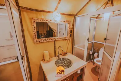 a bathroom with a sink and a mirror at Trek desert Morocco Sarl in Taouz
