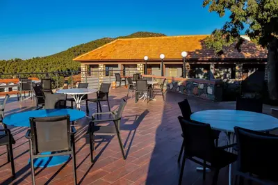 a patio with tables and chairs and a building at Hôtel les truites in Imouzzer Kandar