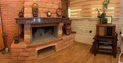 a brick fireplace in a living room with at Hôtel les truites in Imouzzer Kandar