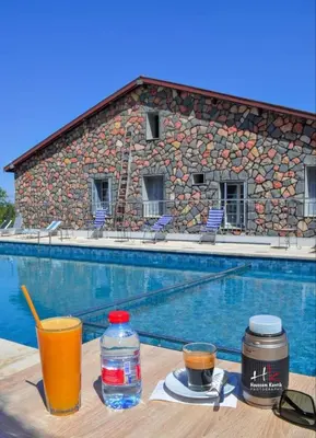 a table with drinks next to a swimming pool at Hôtel les truites in Imouzzer Kandar