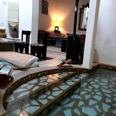 a living room with a tile floor and a fireplace at Riad Safir in Meknès