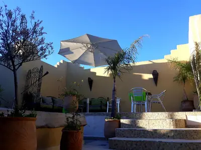 a patio with a table and an umbrella at Riad Safir in Meknès