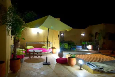a patio with an umbrella and a table and chairs at Riad Safir in Meknès