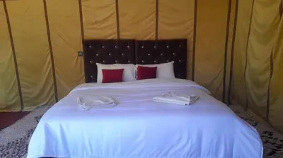 a bed in a tent with two towels on it at Luxury trek desert camp in Merzouga