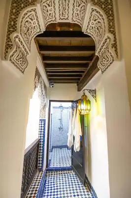 a hallway with a blue and white tile floor and a door at Dar Chez Khadija in Fès