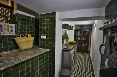 a green tiled kitchen with a sink and a stove at Dar Chez Khadija in Fès