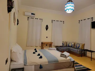 a living room with a bed and a couch at Le Domaine M in Ouzoud
