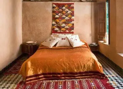 a bedroom with a bed with a quilt on the wall at dar lmallouki in Fès