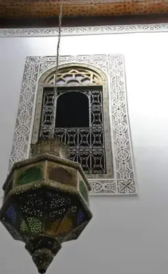 a light hanging from a building with a window at dar lmallouki in Fès