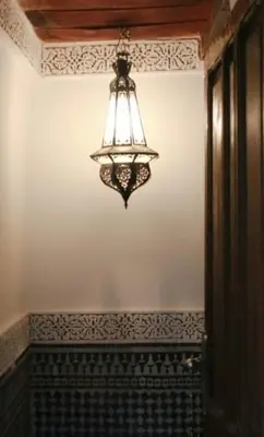 a chandelier hanging from a wall in a room at dar lmallouki in Fès