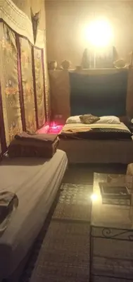 a room with two beds and a table in it at dar lmallouki in Fès