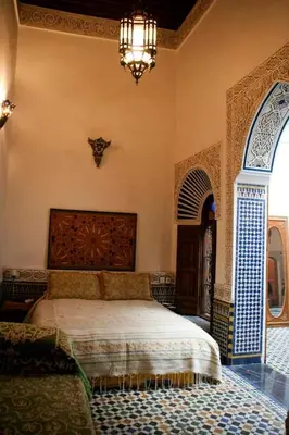 a bedroom with a bed and a chandelier at dar lmallouki in Fès